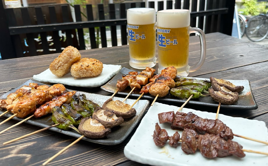 Assorted yakitori skewers and Japanese beer served outdoors in Kobe, Japan