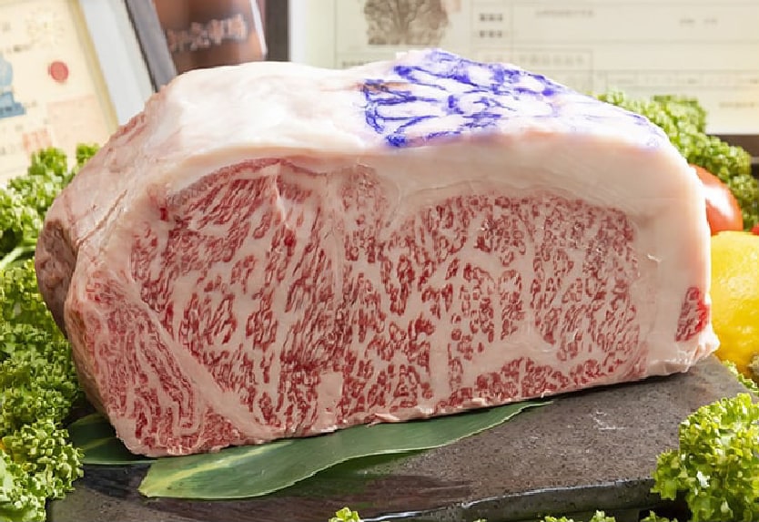 Premium Kobe beef with rich marbling prepared for a charcoal-grilled yakitori experience in Kobe, Japan